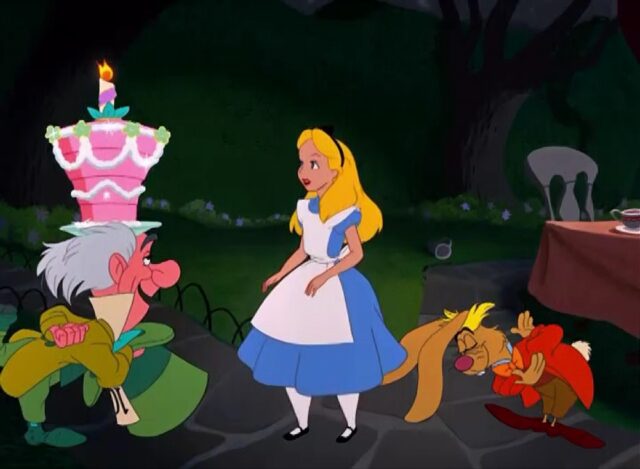 Alice stands between the Mad Hatter and the March Hare. The Mad Hatter is presenting a tall, pink layered cake with a single lit candle on top, symbolizing an un-birthday celebration.