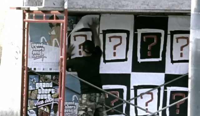 A person is pasting posters on a wall, featuring a red question mark inside a square frame.