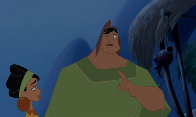 The character Pacha from the animated movie "The Emperor's New Groove" is closing his right eye, looking up and holding up his index finger while thinking, indicating he's about to lie, while Chicha, his wife, looks at him.