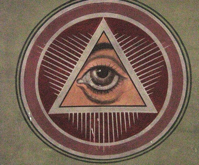 A ceiling painting of the Eye of Providence in the Dormition of the Theotokos Cathedral in Romania. The eye is enclosed within a triangle, surrounded by a red circular background with radiating white lines.