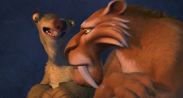 Sid the sloth and Diego the saber-toothed tiger are sitting close together, sharing a moment by a campfire. Sid is talking, while Diego looks pensive. The firelight highlights their expressions, creating a warm and intimate atmosphere.