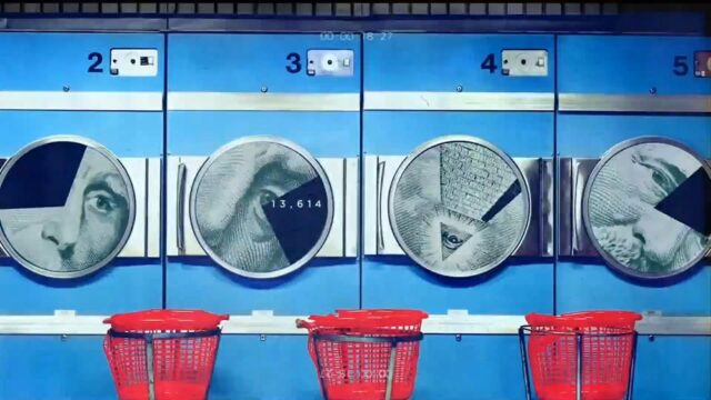 A still from the opening credits of "Real Time with Bill Maher," featuring a row of washing machines with parts of U.S. dollar bill imagery in each drum. A piece of three of the images is missing, partially hiding one eye in each image. The third machine shows the Illuminati pyramid with the Eye of Providence. Red laundry baskets are lined up below the machines.