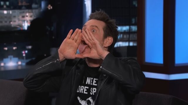 Jim Carrey sticks his tongue out while holding his hands around it in the shape of a triangle during an appearance on "Jimmy Kimmel Live," parodying the all-seeing eye symbol.