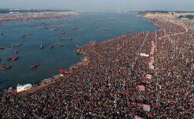 An aerial view of the Kumbh Mela in India (2024), showcasing an immense crowd of devotees gathered along the banks of a river. The sheer number of people highlights the scale of this significant Hindu pilgrimage, known as the largest peaceful gathering in the world.