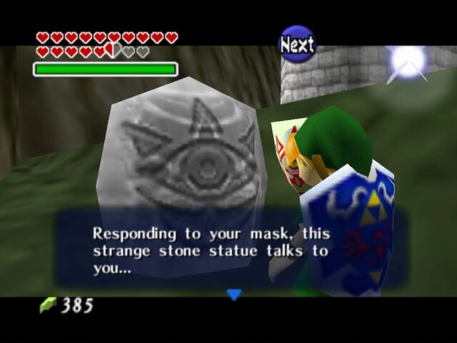 The character Link wearing the Mask of Truth and interacting with a Gossip Stone in The Legend of Zelda: Ocarina of Time. The stone responds to the mask and begins to communicate with Link, about to reveal a secret.