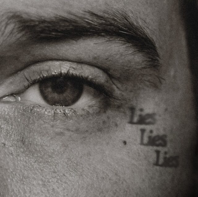 A close-up of a human eye with the word "Lies" repeatedly written underneath. The black-and-white image evokes a theme of deception.