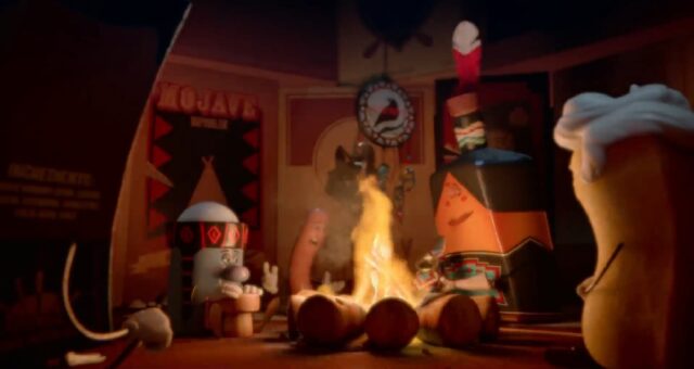 Animated characters, resembling grocery store items, sit around a campfire in a cozy, indoor setting. Some of the characters are adorned with Native American-inspired headbands and attire. The scene includes a sausage, a twinkie, and other anthropomorphized grocery store items. The background features Native American-themed decorations and posters.