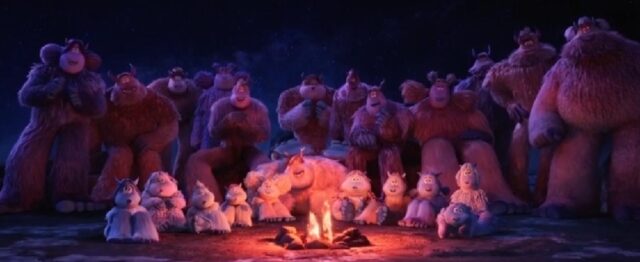 A group of yetis gathered around a campfire at night. The yetis, both adults and children, are sitting and standing in a semicircle, enjoying the warmth and light of the fire under the starry sky.