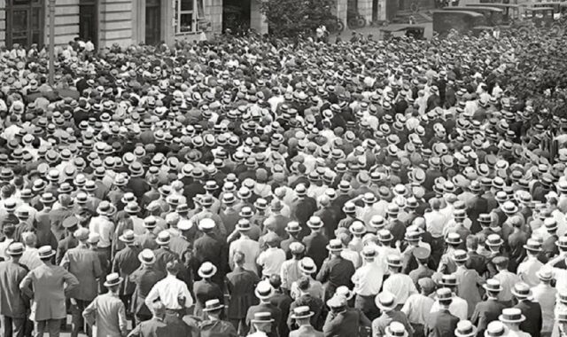 A black and white photograph showing a large crowd of people, mostly men, all wearing straw hats. This image is from the Straw Hat Riot of 1922.